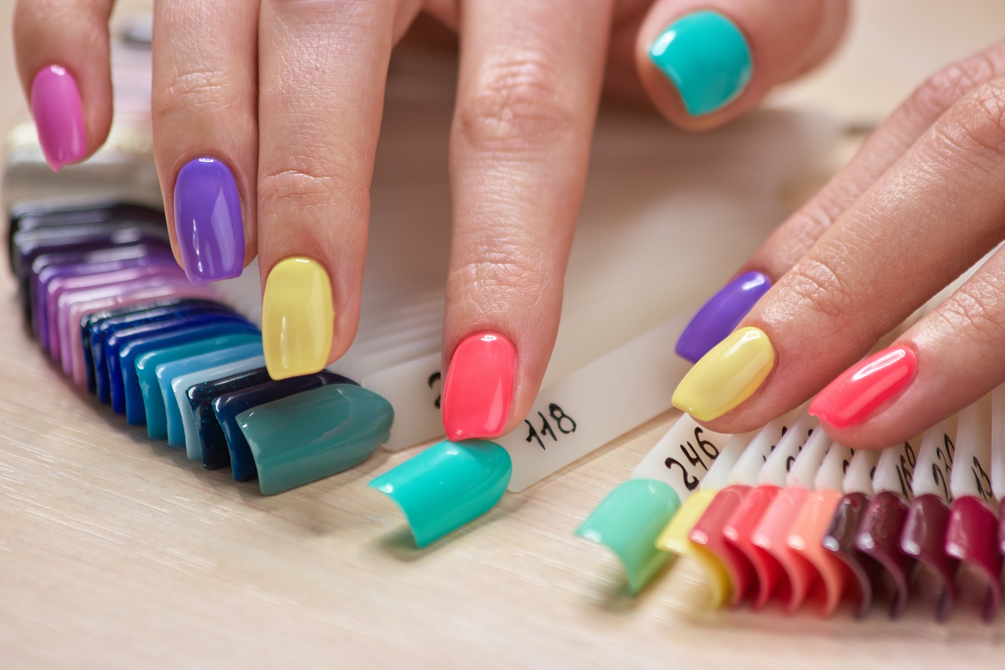 Manicured fingers touching nails samples